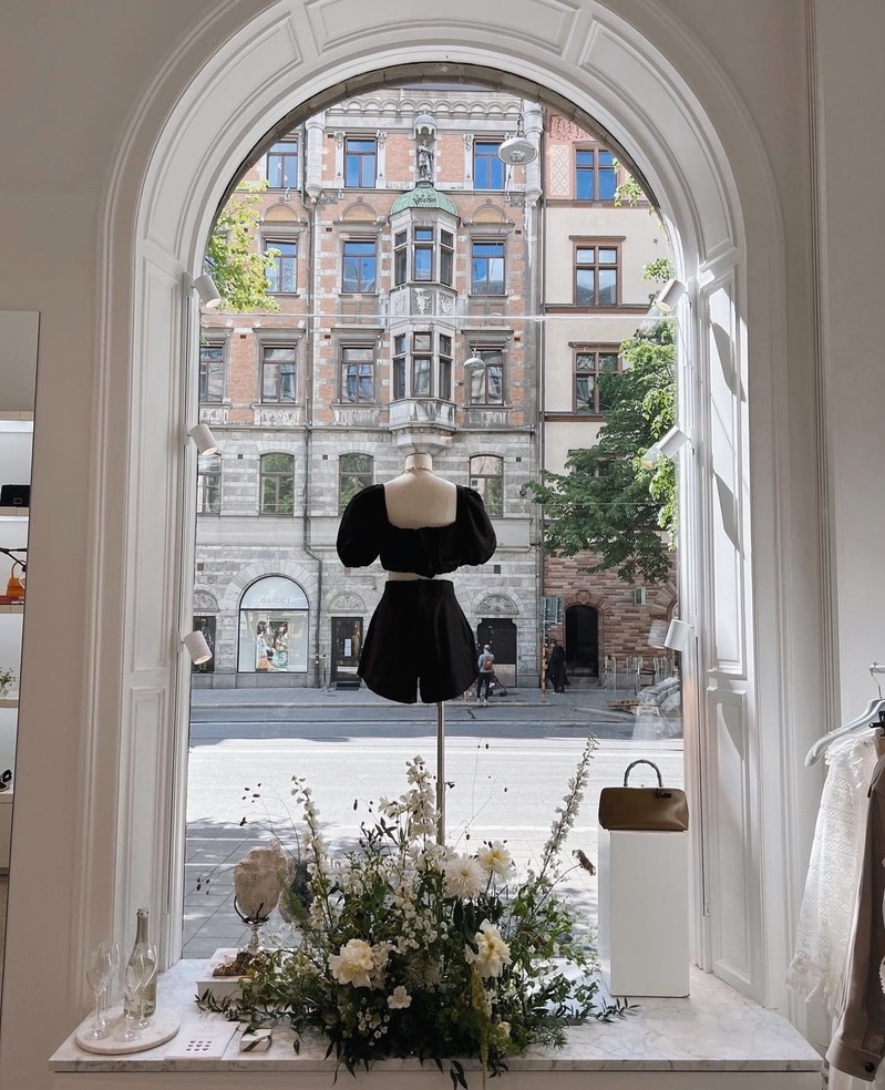 Blomsterarrangemang med vita blommor i ett skyltfönster