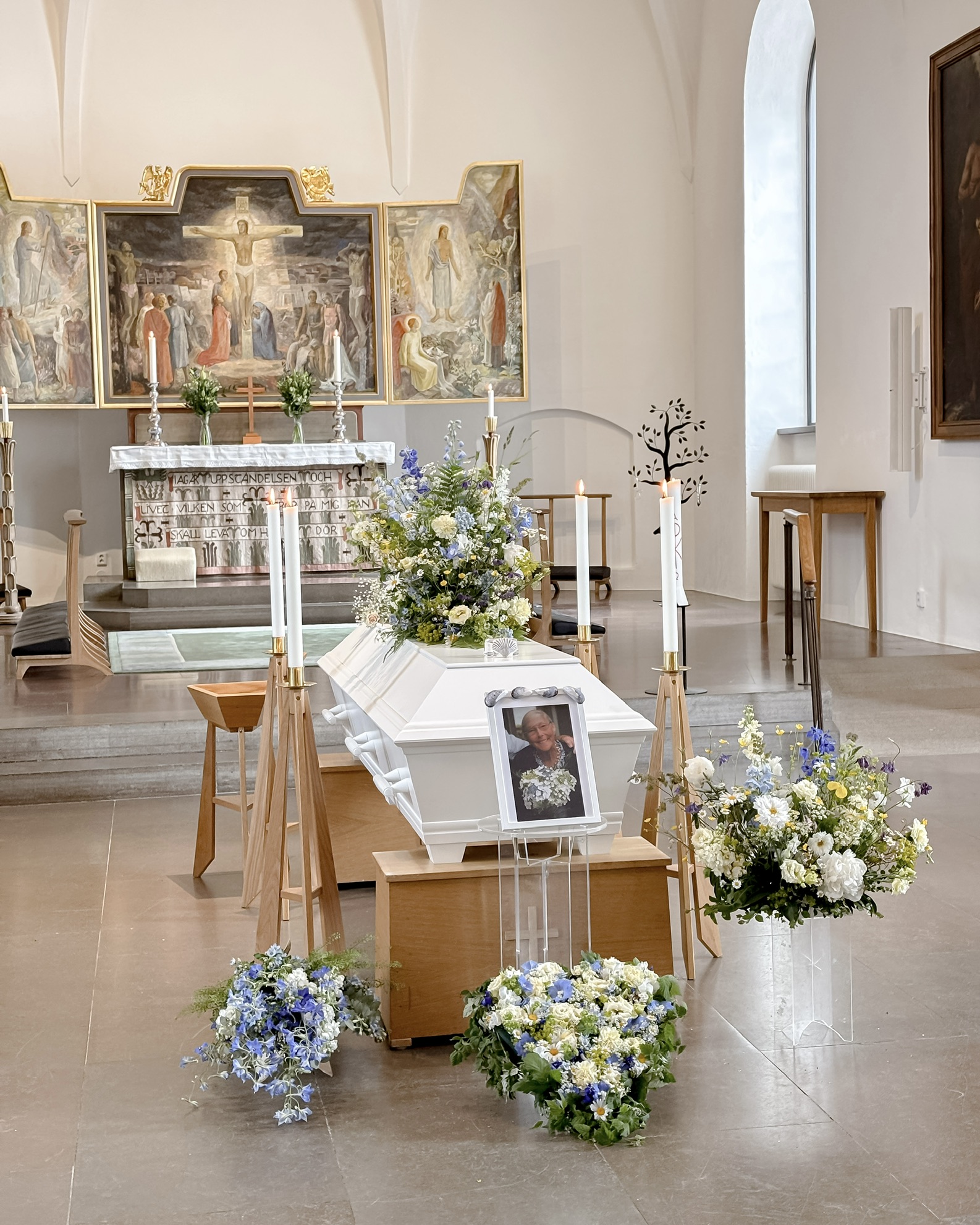 Kista prydd med blommor i ljus kyrka