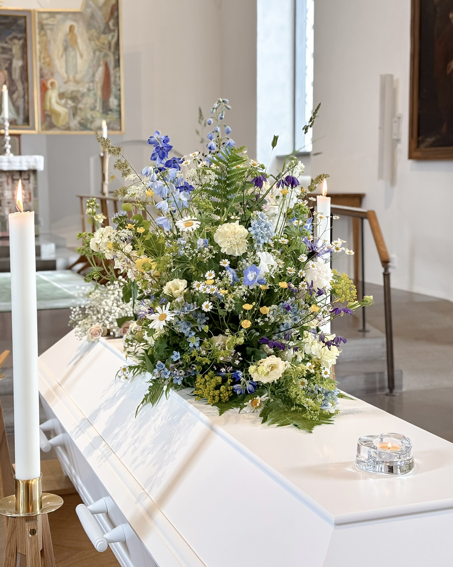 Kistdekoration med blå och vita sommarblommor